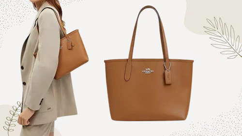 Coach leather handbag with a tan body, burgundy striped strap, and a luggage tag attached.