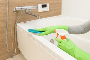 Best bathtub cleaner being used with scrub brush and spray in modern bathroom.