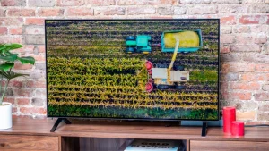 Aerial view of a tractor harvesting crops on TV screen.