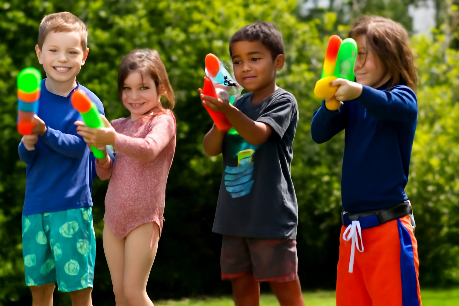 Best water guns for kids being used by four children in a sunny backyard.