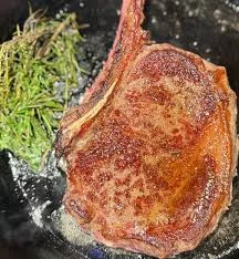 Best steak delivery showcasing seared bone-in ribeye with herbs