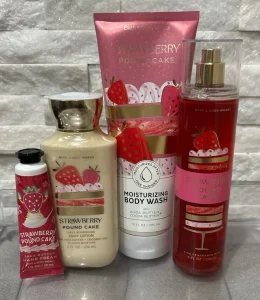 Collection of Strawberry Pound Cake body care items in pink packaging with strawberry designs.